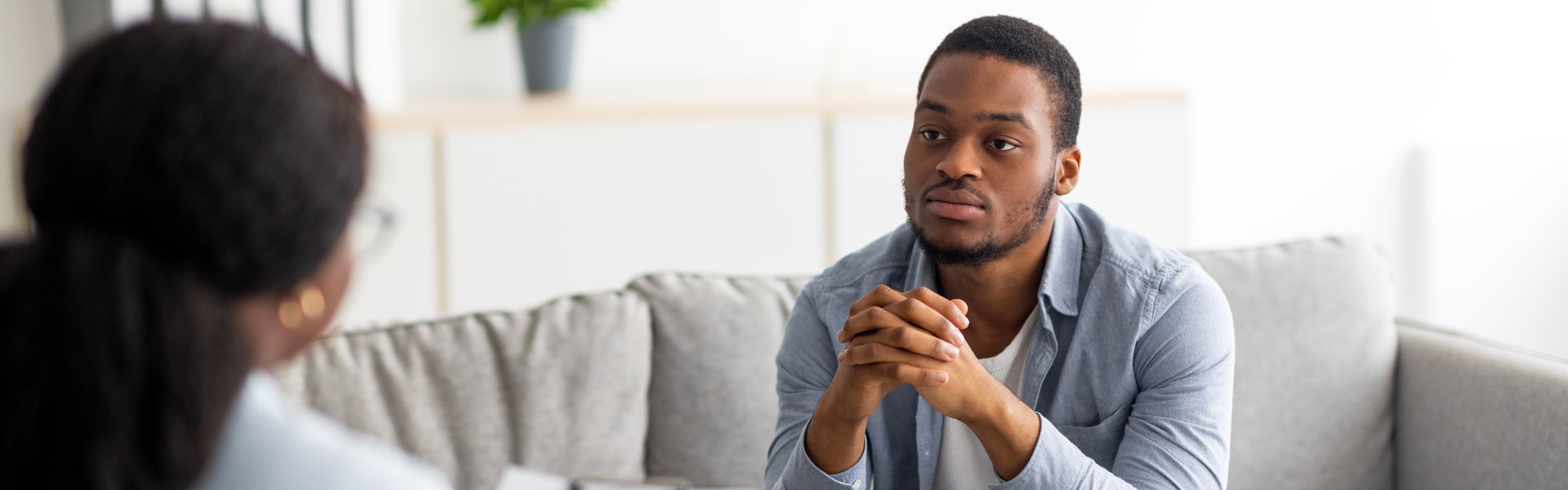 male patient having psychotherapy session with counselor at mental health clinic